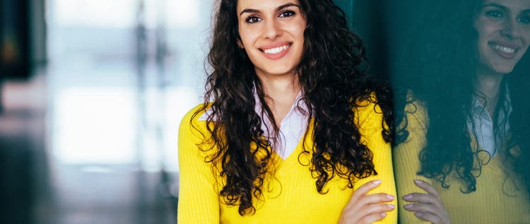 Young woman with arms crossed smiling to the camera