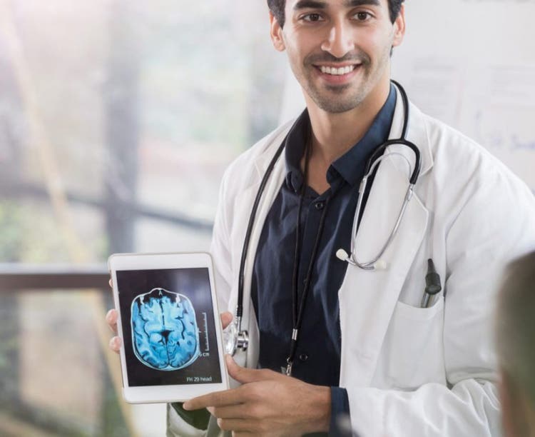 Male doctor showing a brain scan to colleagues.