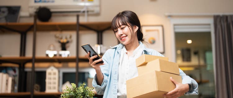 Beautiful Young Woman With Smartphone Receiving Parcel Purchased Online