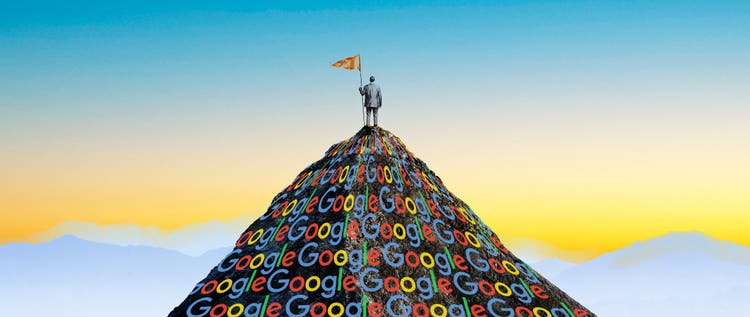 A man standing on top of a dark mountain shape made up of Google logos.