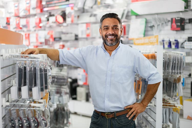 Happy business manager running a tech store and looking at the camera smiling